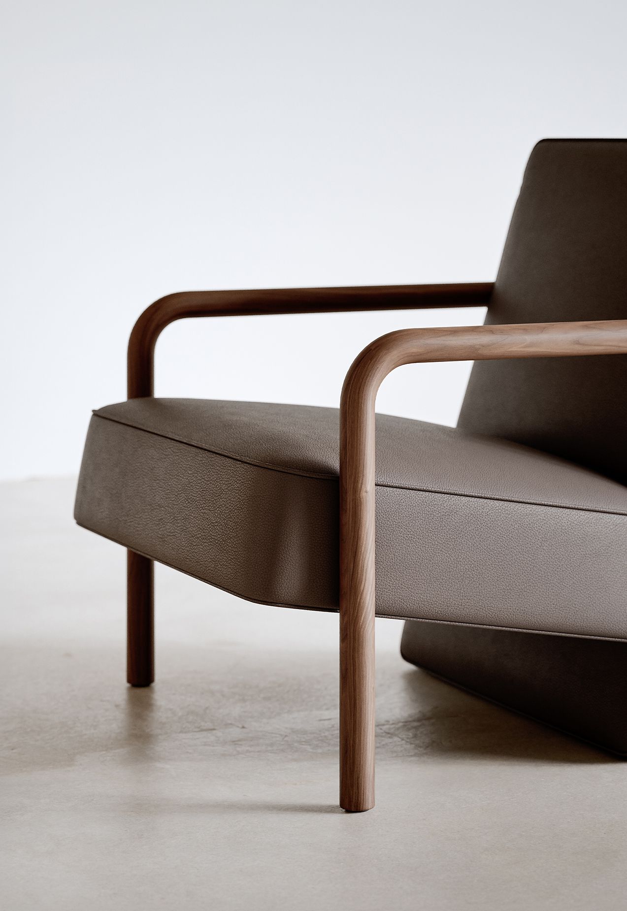 Detail of the Parker chair's wood arm meeting the upholstered body