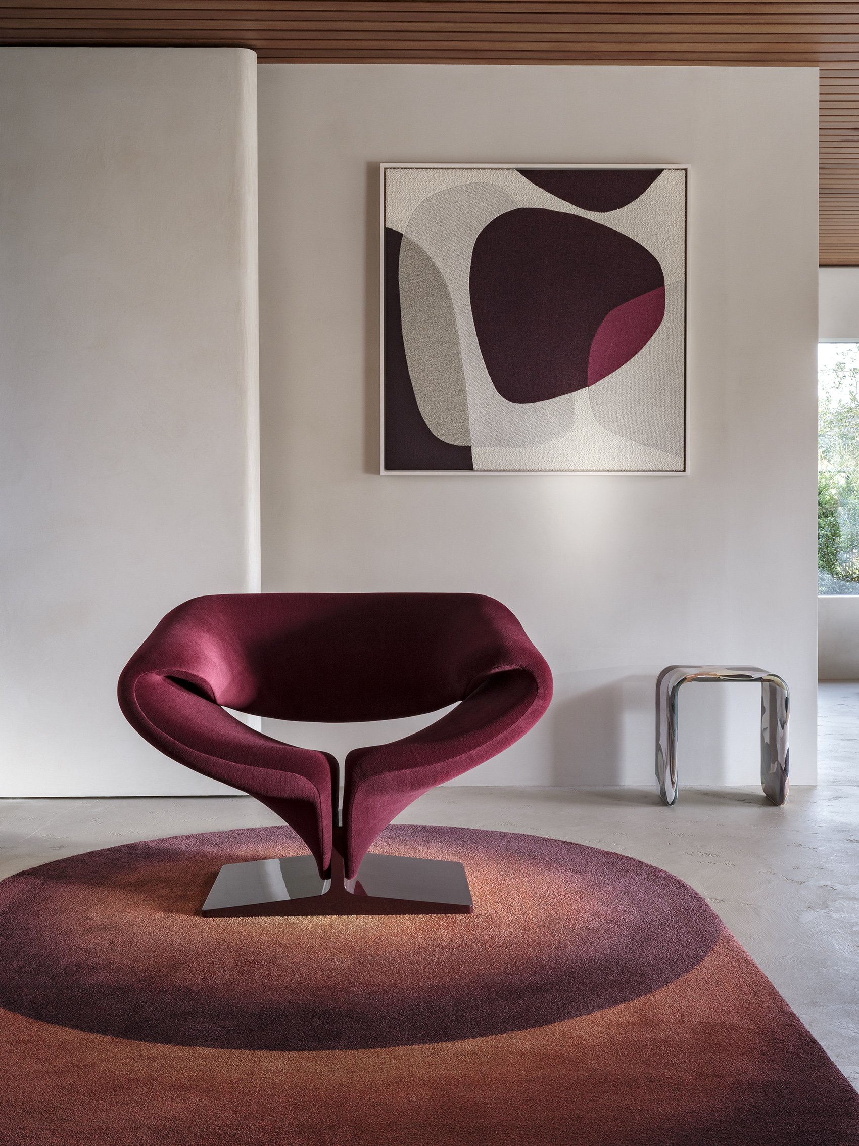 Burgundy Ribbon chair paired with an abstract print and matching round rug