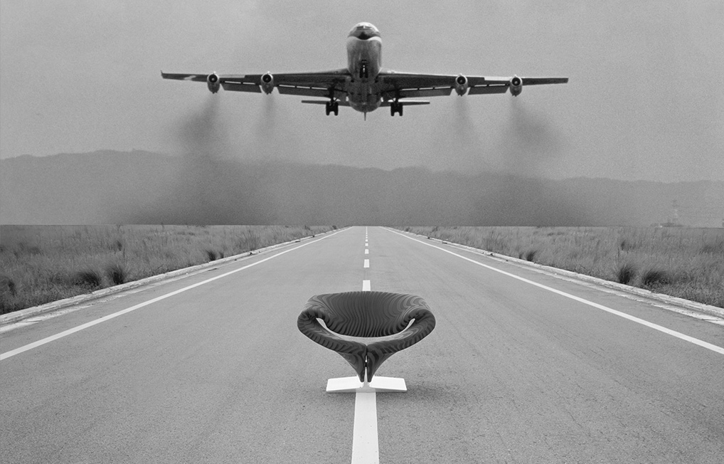 Black-and-white heritage Artifort advertisement showing a Ribbon chair on an airport runway