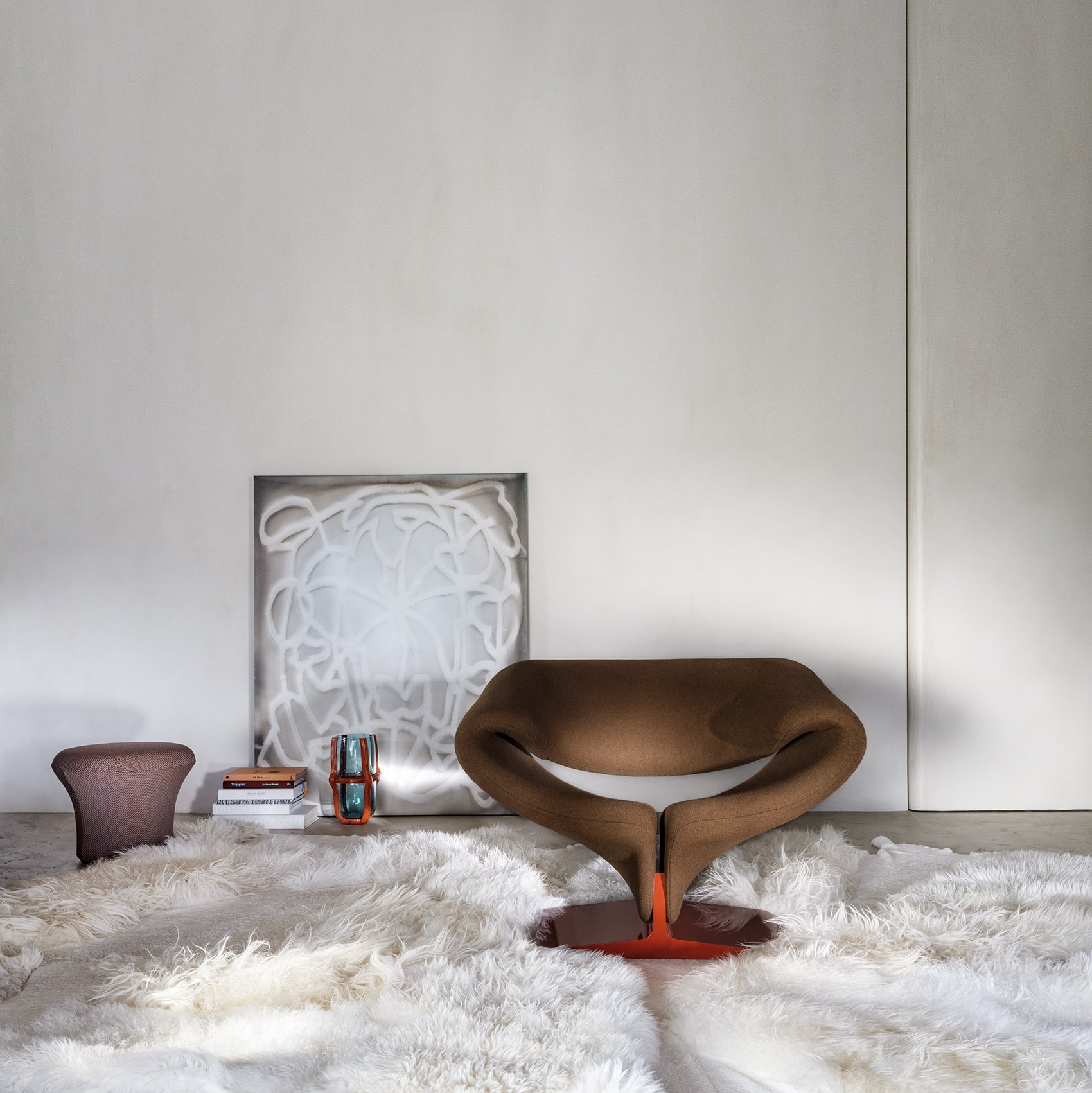 Brown Ribbon chair with a red base in a layered living room with a white rug